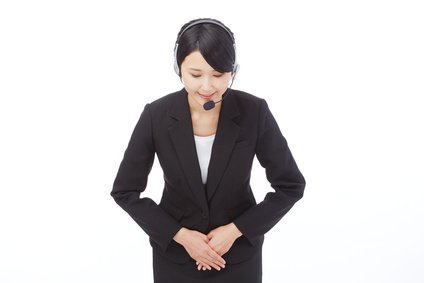 車を売る人からクレームを受けて謝る女性